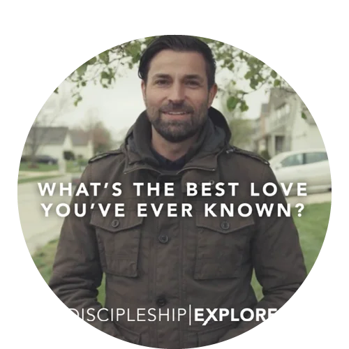 A man in a neighborhood wearing a jacket with text that says "What's the best love you've ever known?"