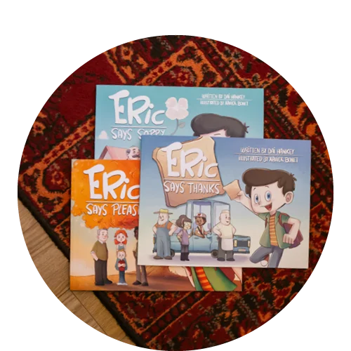 Photograph of the books in the Eric Says series, featuring illustrations, on a wooden table